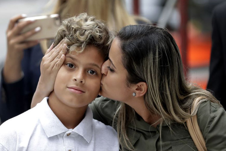 En esta foto del 5 de julio de 2018, Sirley Silveira Paixao, una inmigrante de Brasil en busca de asilo, besa a su hijo Diego Magalhaes, de 10 años, después de que Diego fuera liberado de un centro de detención de inmigrantes en Chicago. Una jueza federal de California desestimó el lunes 9 de julio un pedido del gobierno de EE.UU. para extender el tiempo que los niños inmigrantes pueden permanecer detenidos.