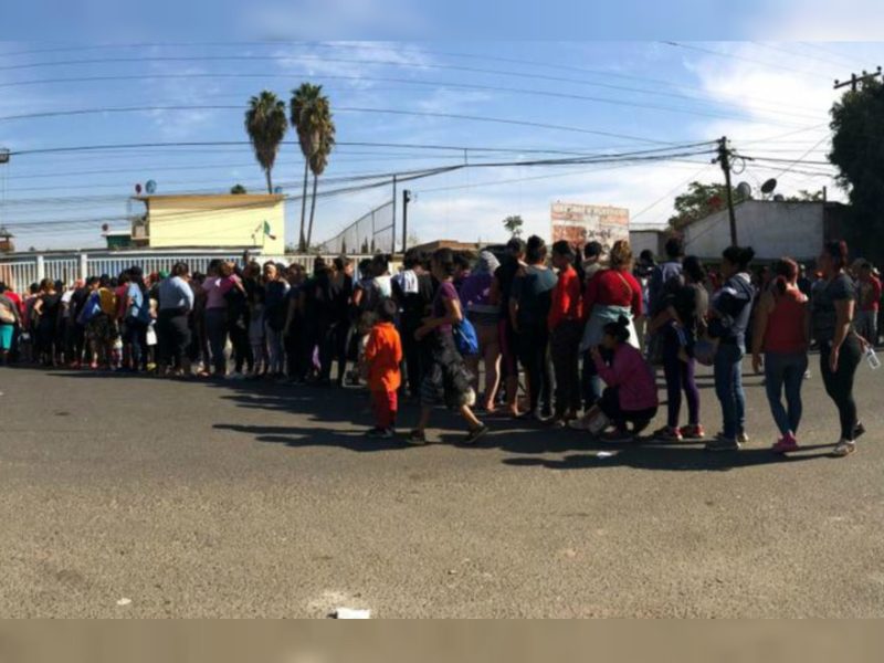 Miembros de la caravana, hacen fila para recibir comida, en Tijuana. Celia Mendoza - VOA