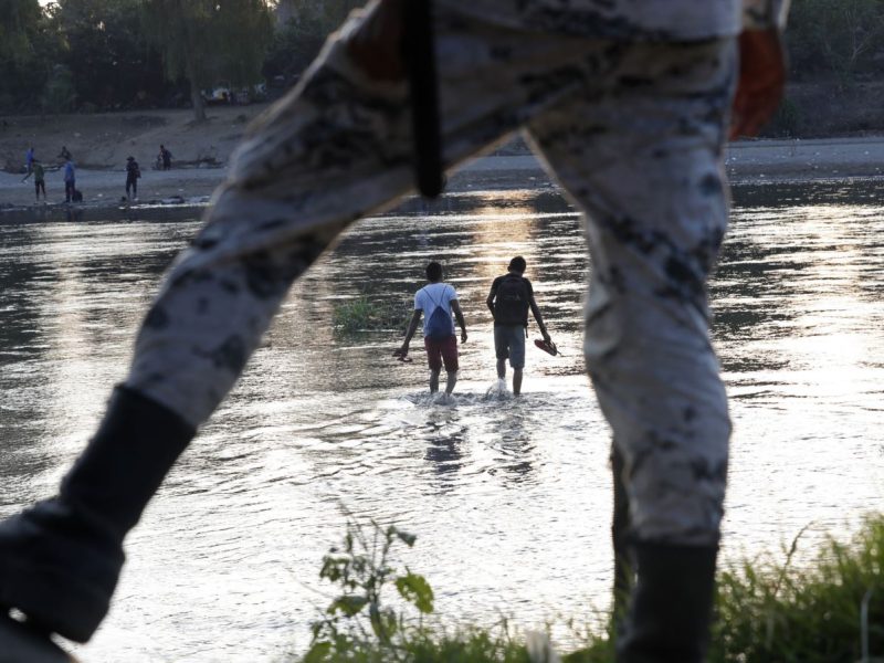 Migrantes hondureños que intentaron ingresar a México a pie regresan al lado guatemalteco del río Suchiate bajo la vigilancia de una Guardia Nacional mexicana cerca de Ciudad Hidalgo.