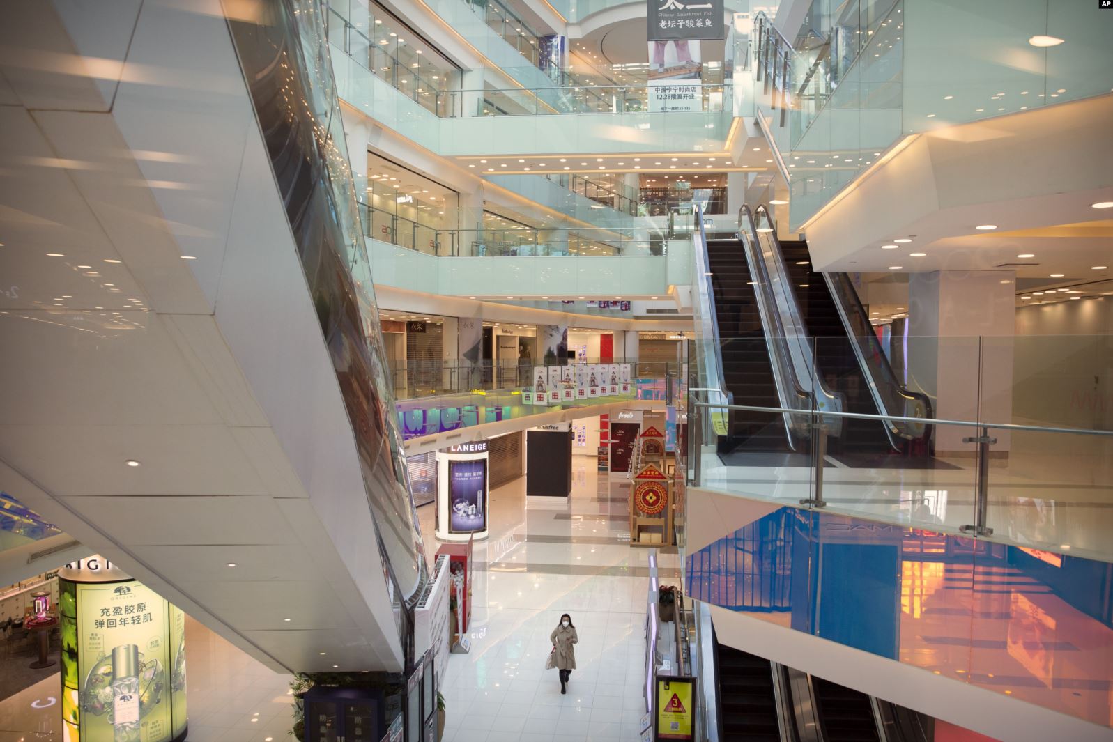 Una mujer con una mascarrilla protectora camina por un centro comercial casi vacío en Beijing, China, el 4 de febrero de 2020.