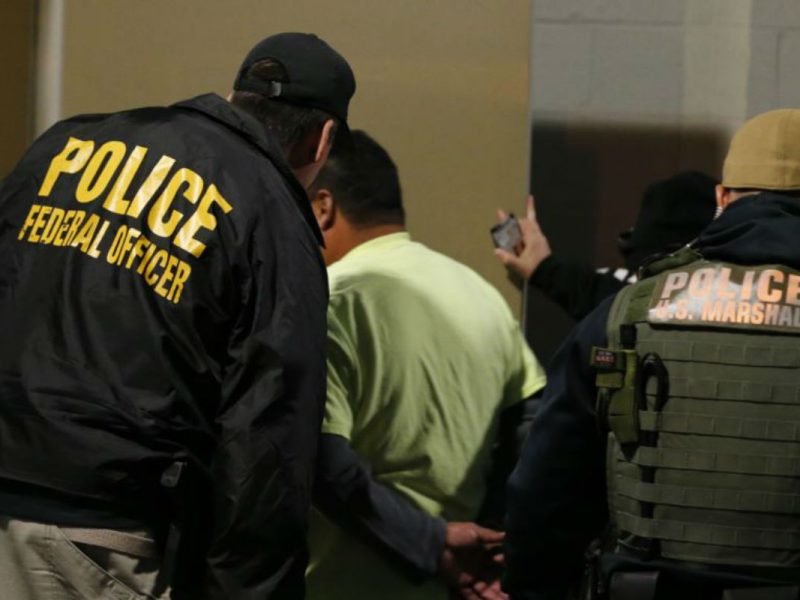 Agentes de ICE trasladan a una persona en una prisión