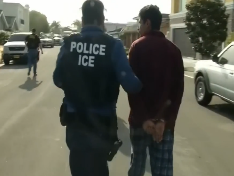 Agente de ICE arrestando a un hombre