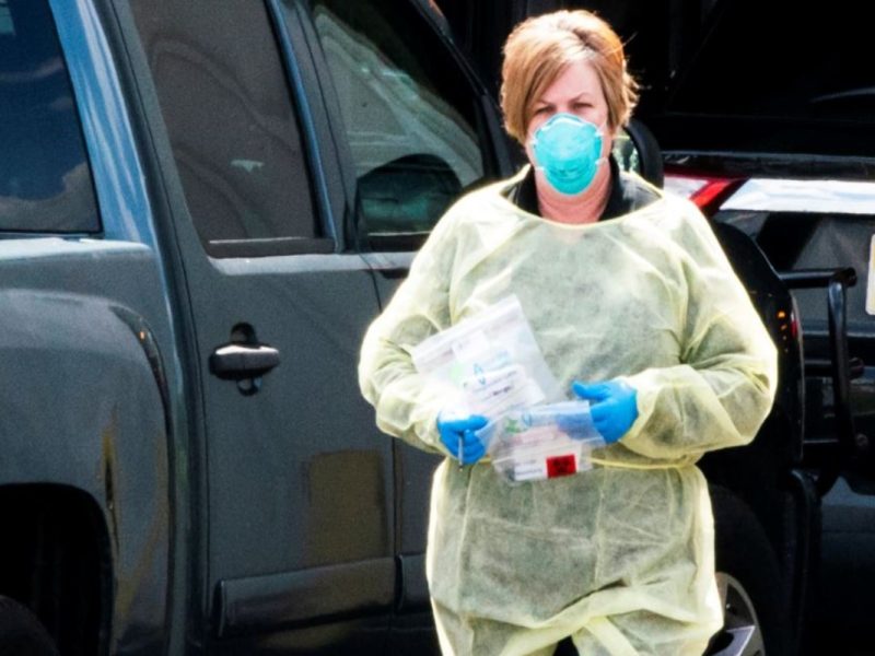 Mujer con cubreboca , guantes y bata para evitar contagio de Covid-19 en EU