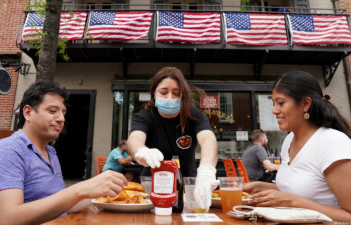 Personas comiendo afuera de un restaurante durante la pandemia de Covid-19