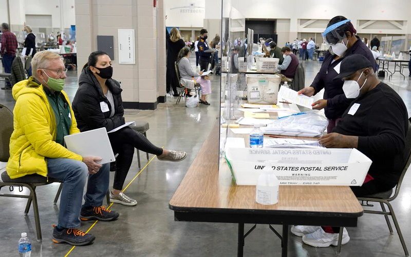 Trabajadores electorales verifican votos bajo la mirada de observadores durante el recuento en el Centro Wisconsin, en Milwaukee, el viernes 20 de noviembre de 2020. Este recuento verificó la victoria de Biden.