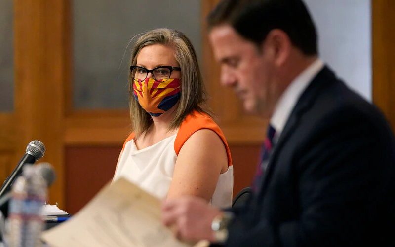 La secretaria de estado de Arizona, Katie Hobbs, y el gobernador Doug Ducey durante la firma de los documentos electorales que certifican la victoria de Joe Biden.