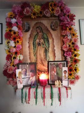 Morenita del Tepeyac con flores alrededor y fotos