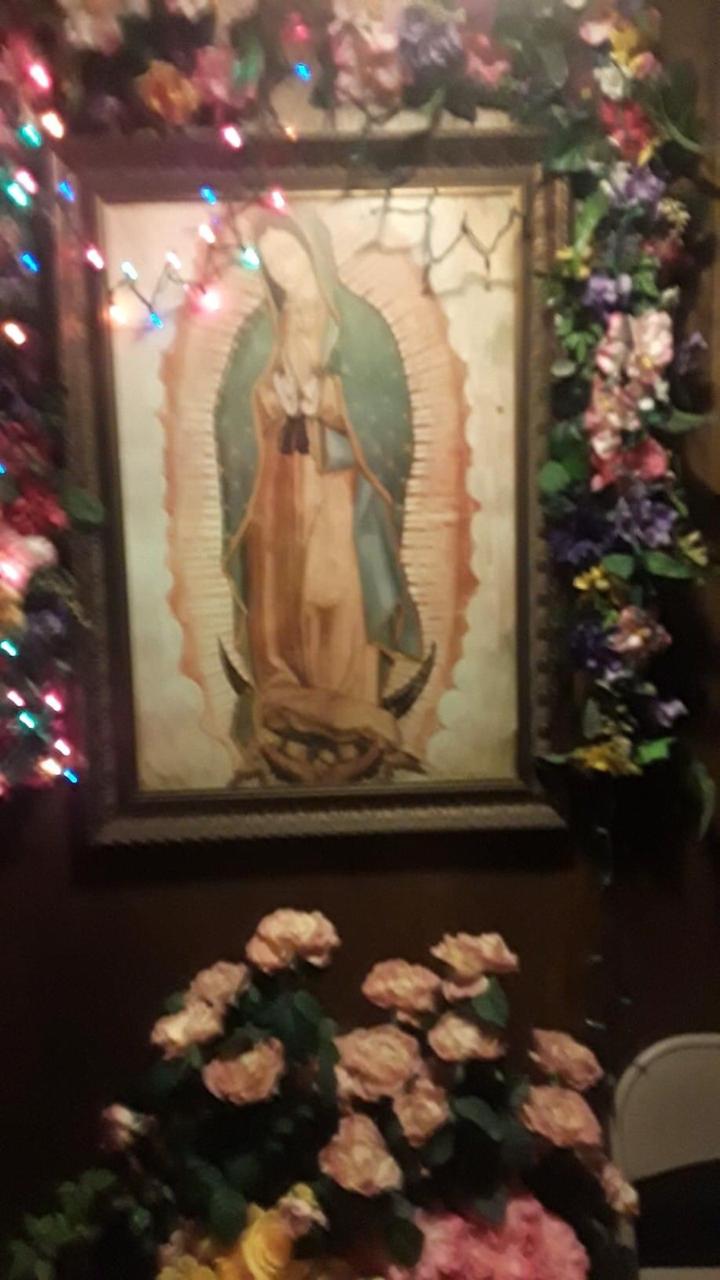 Virgencita con flores y adornos alrededor