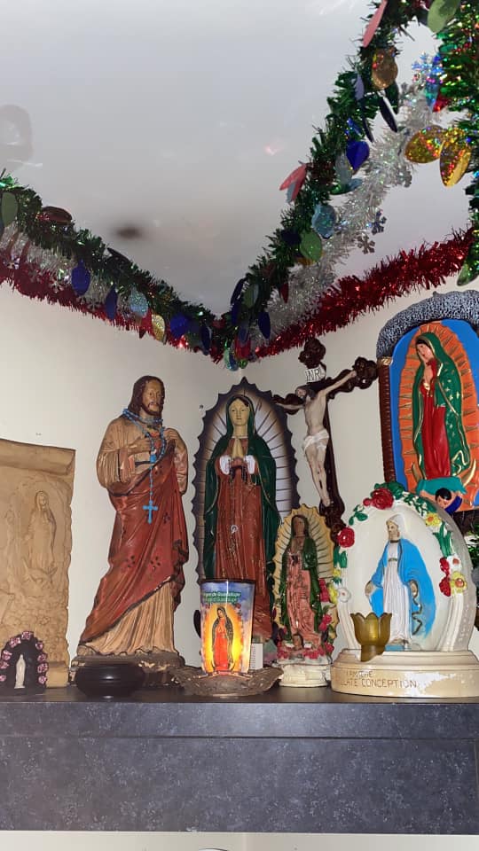 Altar con varias Virgenes en diferentes tamaños, un sagrado corazón de Jesús y veladoras