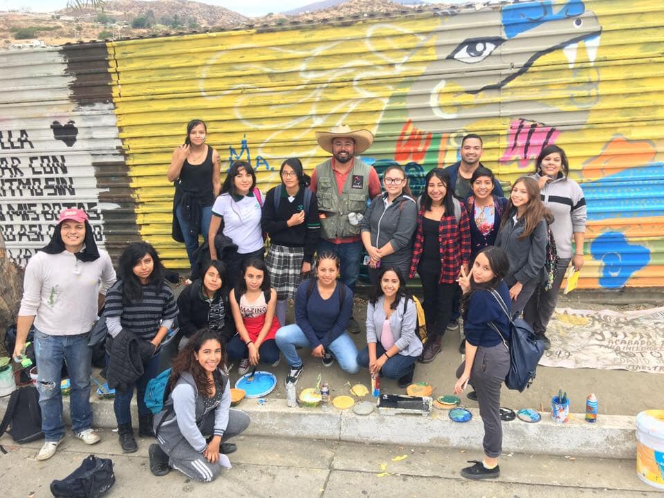 Colaboradores pintando en el muro fronterizo