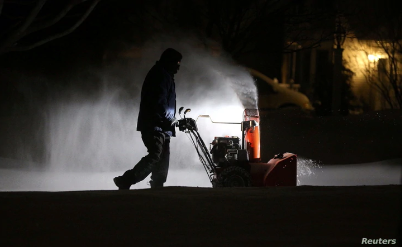 Roger Hake recibe ayuda de las luces de su camión mientras quita la nieve de la entrada antes de que salga el sol en Webster, cerca de Rochester, Nueva York, el 16 de febrero de 2021. | Foto: Jamie Germano / Rochester Democrat y Chronicle / USA Today.