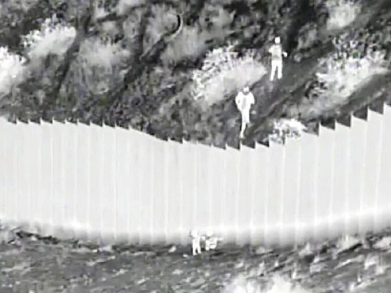 Captura de pantalla de un video de la Oficina de Aduanas y Protección Fronteriza capta el momento en el que traficantes lanzan a dos niñas desde lo alto del muro fronterizo con México en Santa Teresa, Nuevo México, el 30 de marzo de 2021.