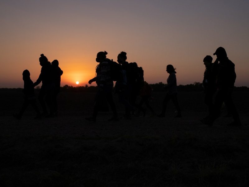El sol sale mientras migrantes caminan hacia el muro fronterizo de Estados Unidos en búsqueda de asilo