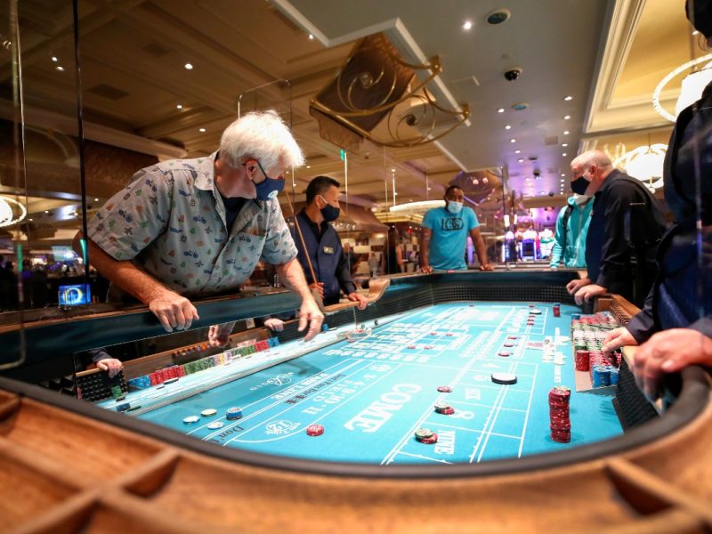 Un hombre juega en una mesa protegida por un vidrio plastificado en el hotel Bellagio en Las Vegas, Nevada. 4 de junio de 2020.