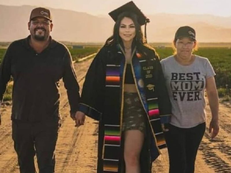 Universitaria graduada se toma fotos con sus padres migrantes en el campo