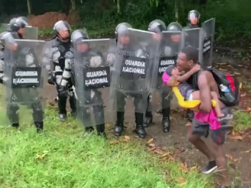 Miembros de la Guardia Nacional encapsulando a un hombre que viajaba con su hijo en la caravana migrante.
