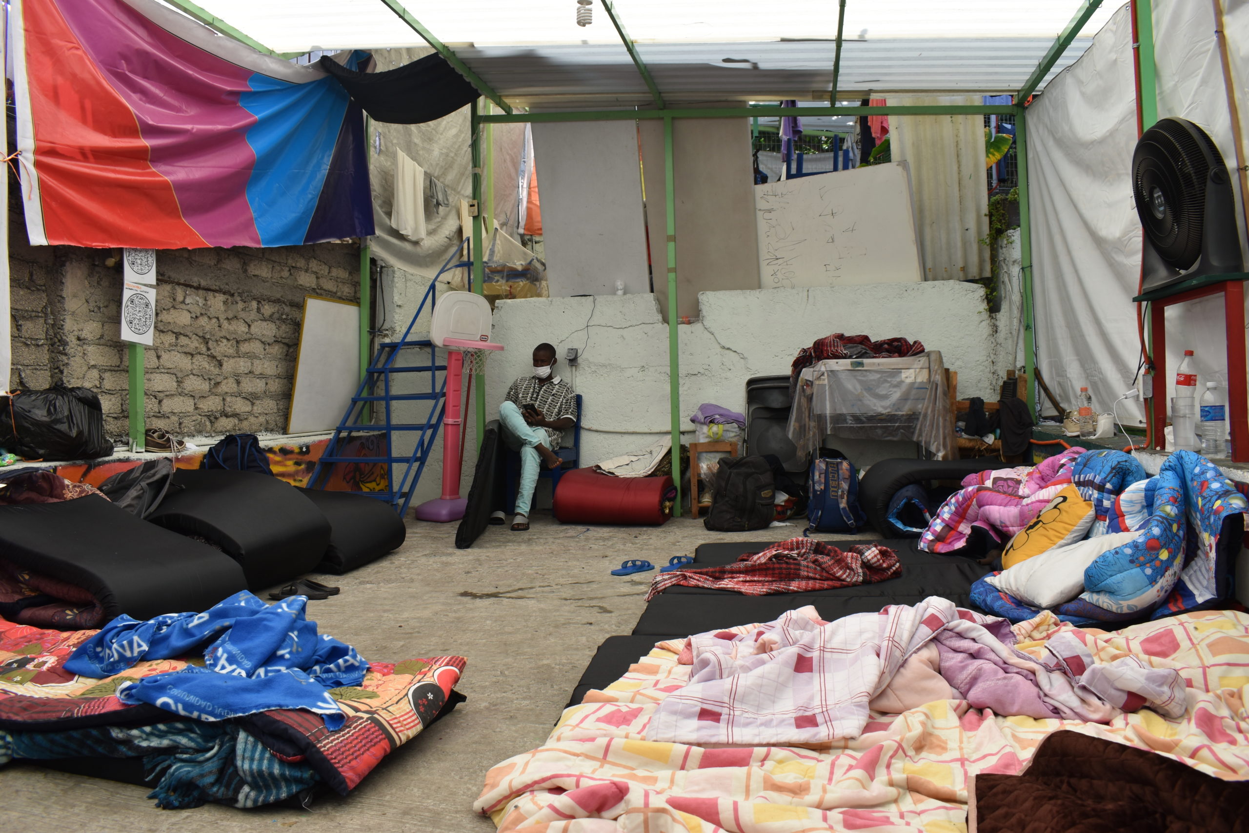 Las áreas de Casa Tochán destinadas a actividades físicas como basquetbol y boxeo han tenido que ser ocupadas como "dormitorios" temporales. Aquí no hay espacio para la privacidad. | Foto: Emilio Almaraz / Conexión Migrante.