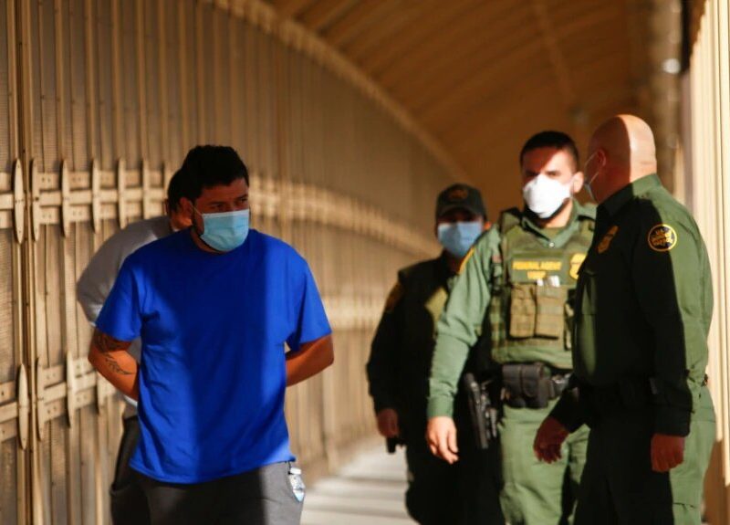 Migrantes son escoltados por agentes de la Patrulla Fronteriza en el Puente Fronterizo Internacional Lerdo Stanton para ser devueltos a México por el programa Quédate en México.