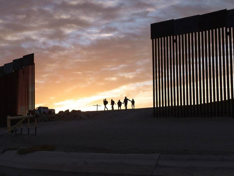 Un par de familias migrantes atraviesan una brecha en el muro fronterizo para llegar a Estados Unidos luegPolíticas migratorias de Estados Unidos