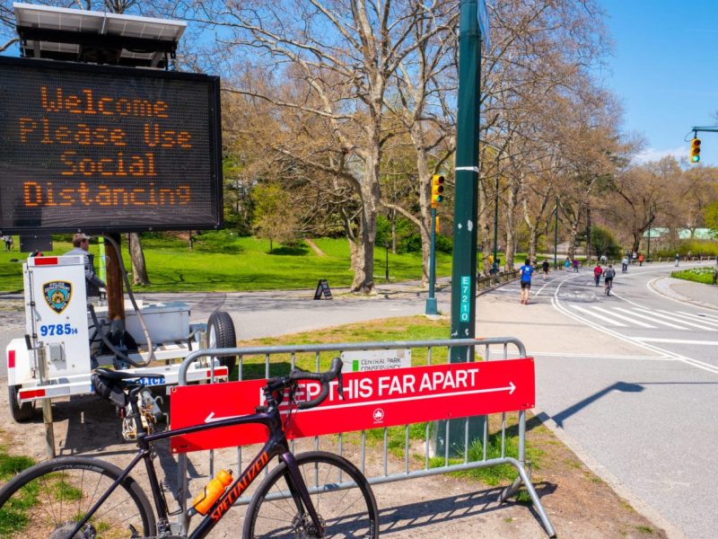 Central Park, New York, USA - April 19, 2020: New York City parks dept and NYPD display a sign demonstrating social distancing during the coronavirus pandemic lockdown in New York.
