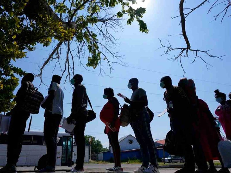 Migrantes hacen fila en un centro de descanso después de que cruzaron la frontera entre Estados Unidos y México