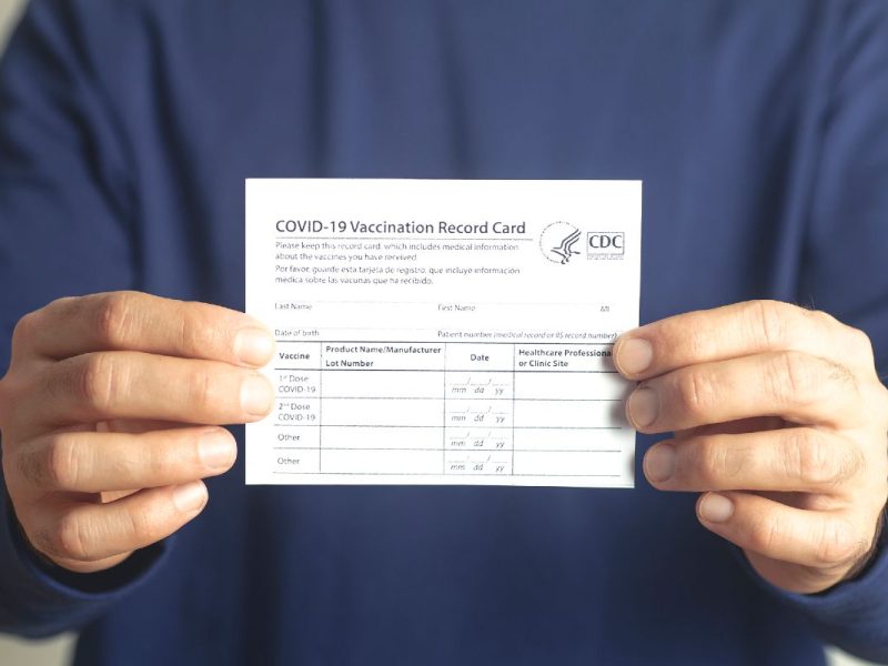 Una persona sostiene una tarjeta de vacunación de Covid-19.