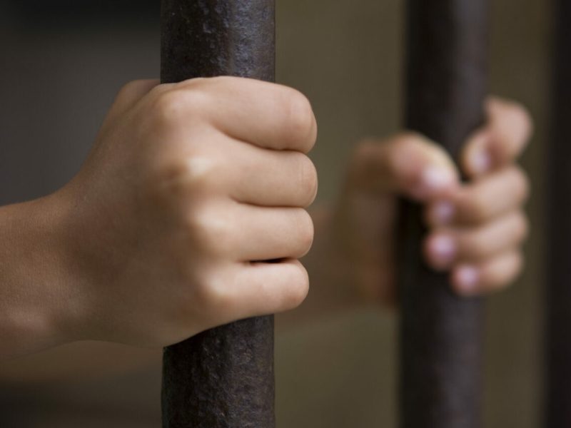 Manos aferradas a unos barrotes