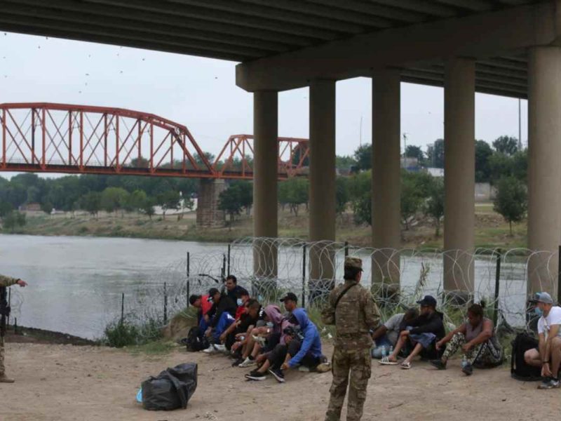 Los migrantes que cruzaron el río Bravo hacia EEUU están bajo la custodia de miembros de la Guardia Nacional mientras esperan la llegada de los agentes de la Patrulla Fronteriza para que los deporten a México bajo el Título 42.