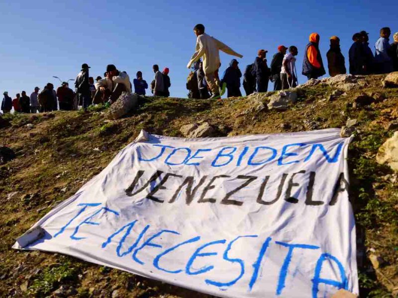 Migrantes venezolanos, algunos expulsados de EEUU a México bajo el Título 42 y otros que aún no han cruzado tras las nuevas políticas migratorias, hacen fila para recibir alimentos