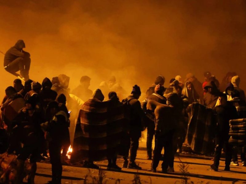 Migrantes esperan cerca del muro fronterizo después de cruzar el Río Grande para entregarse a la Patrulla Fonteriza de EEUU y solicitar asilo