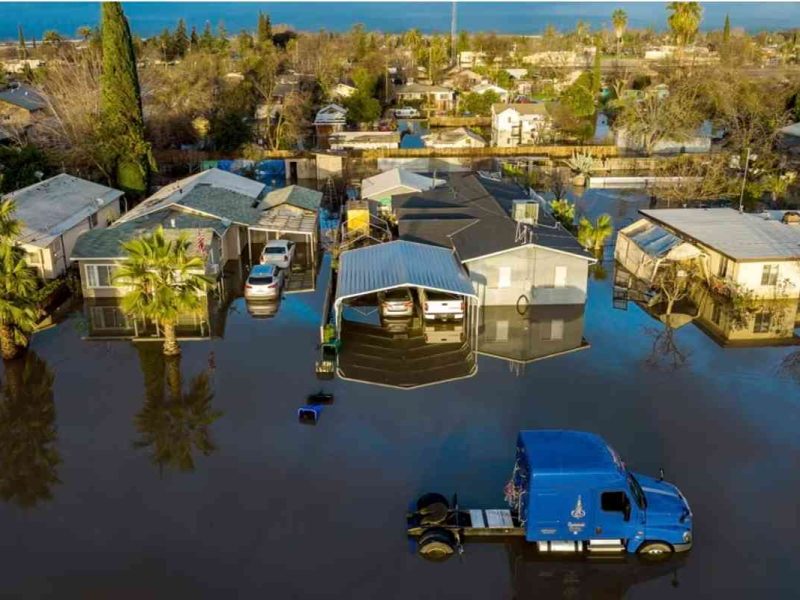 Casas y vehículos rodeados de una inundación tras varios días de lluvias en la población Planada del condado Merced, California