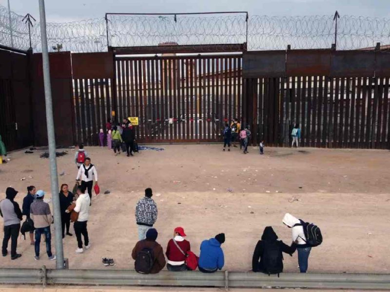 Los migrantes esperan en el muro fronterizo de Ciudad Juárez, Chihuahua, para poder aplicar para el parole humanitario.