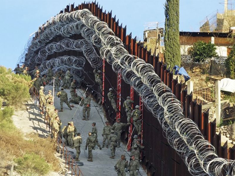 Fotografía del sábado 2 de febrero de 2019 de soldados de la Armada de Estados Unidos colocando alambre de púas adicional en una cerca en la calle Nelson en el centro de Nogales, Arizona.